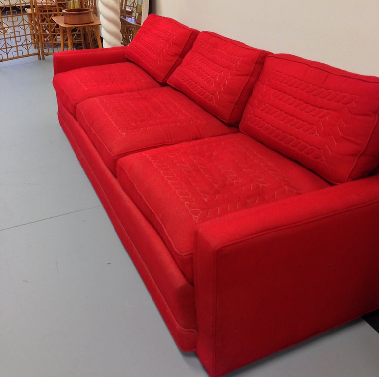 A stunning red custom sofa manufactured by the Pullman Couch Company of Mississippi.  The goose down filled cushions have a white cable stitched design woven into the wool fabric.  The base is raised on small casters and all manufacturer labels